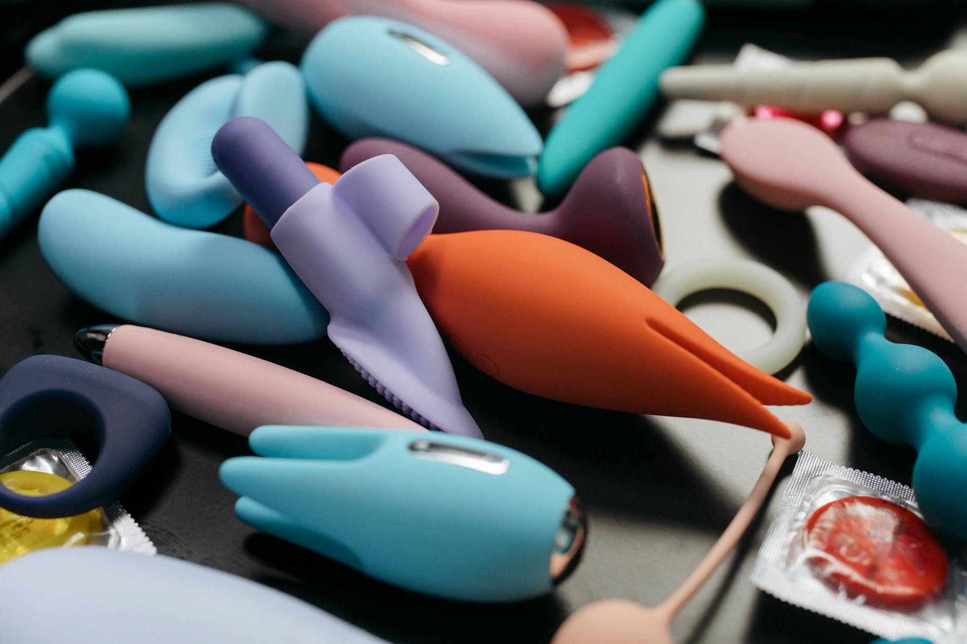 Mãos segurando um vibrador azul elegante contra fundo roxo